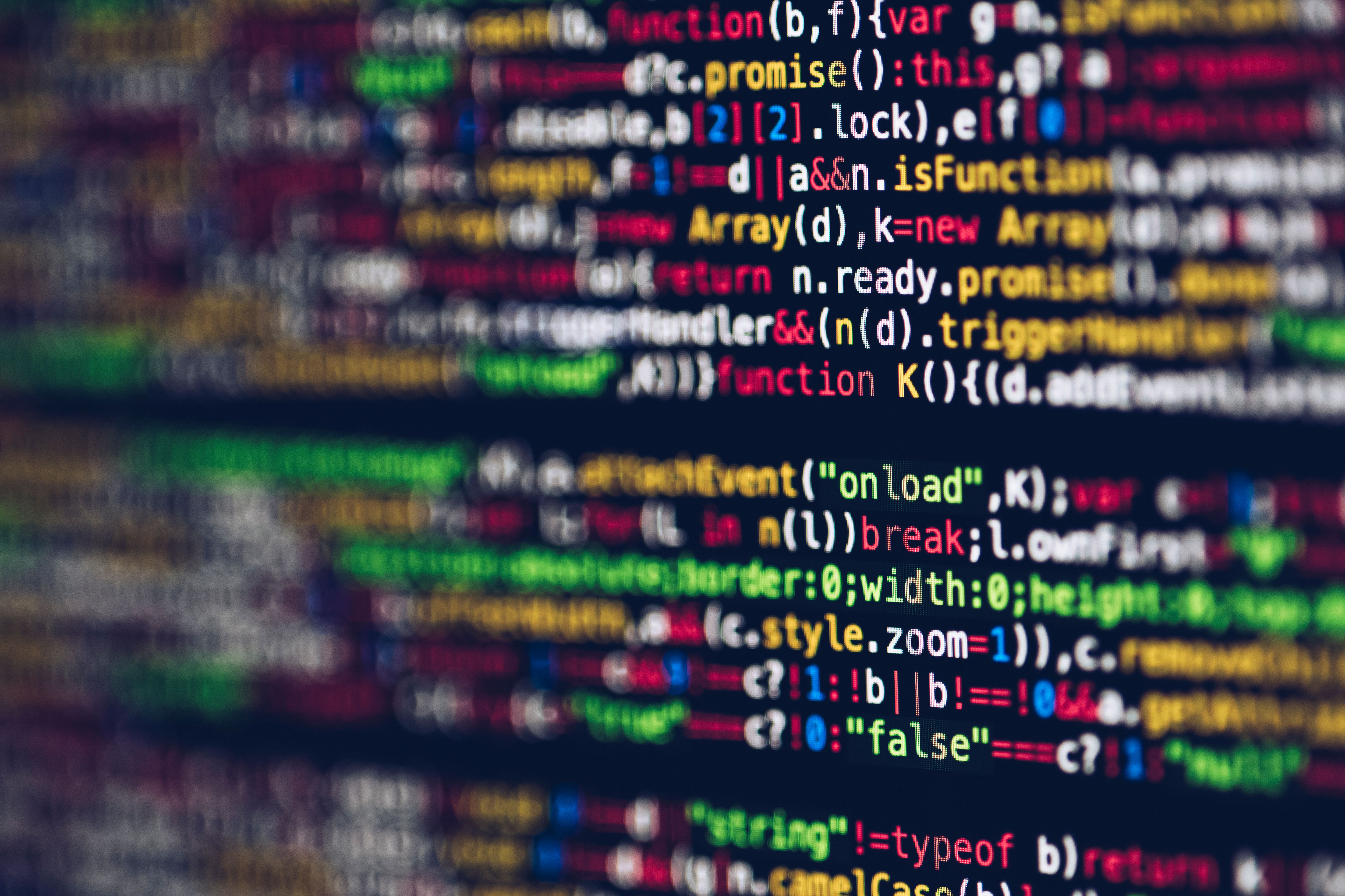 Developer writing code on multiple monitors